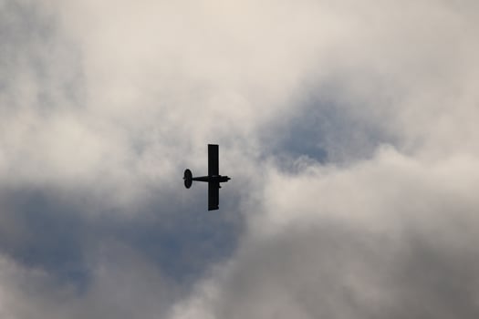 Small plane flying in the sky against dark clouds photo