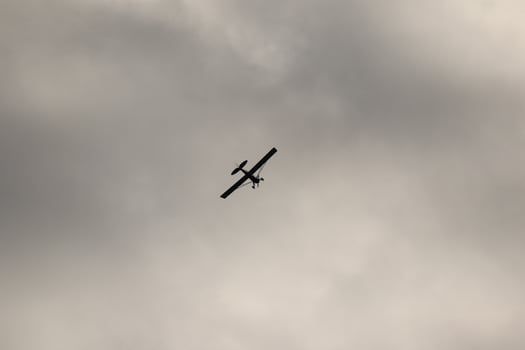 Small plane flying in the sky against dark clouds photo