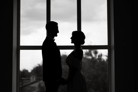 groom in a black suit tie and the bride in a bright studio photo