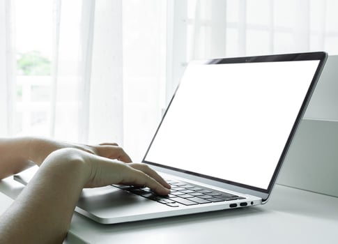 Woman hands using laptop with blank screen on white table at home or office. photo