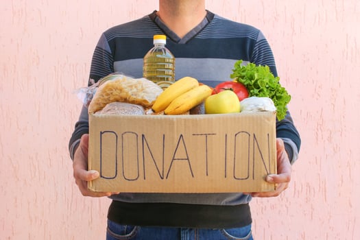 Man holds donation box with food. photo