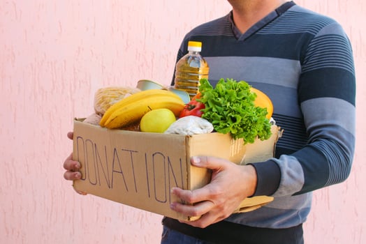 Man holds donation box with food. photo