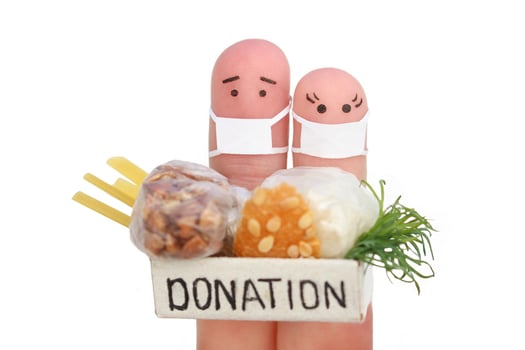 Fingers art of couple with face mask. Man  and woman holding donation box with food isolated on white. photo