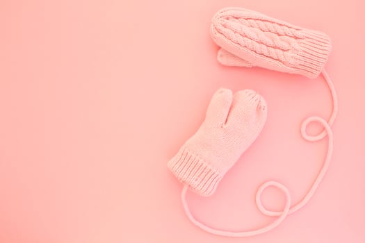 Close-up pink mittens and shaped of string on pink background. Lifestyle and warm feelings concept. Valentine day. Monocolor romantic pattern. Winter theme. Flat lay composition. Top view. Copy space photo