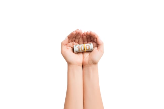 Rolled up dollar bills in female palms on white isolated background. Poverty and poor concept photo