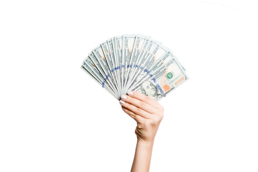 Female hand holding a fan of dollar banknotes on isolated background. Succes and investment concept photo