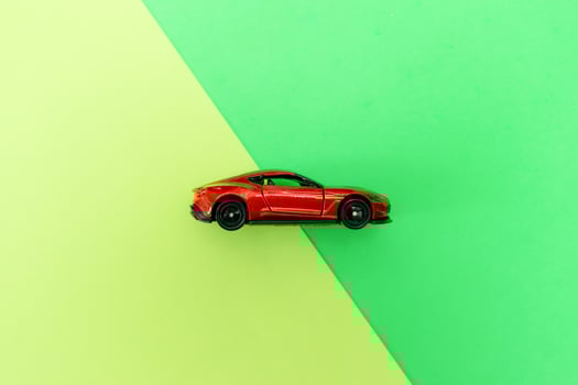 Red toy car isolated on two color background paper, after some edits. photo