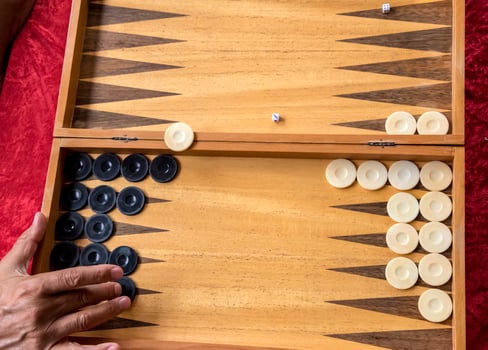 a man moves a pool in a backgammon game photo