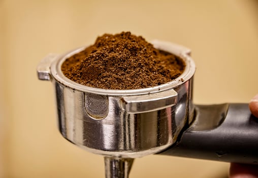 Close up of barista holding portafilter for espresso coffee machine. Espresso preparation. photo