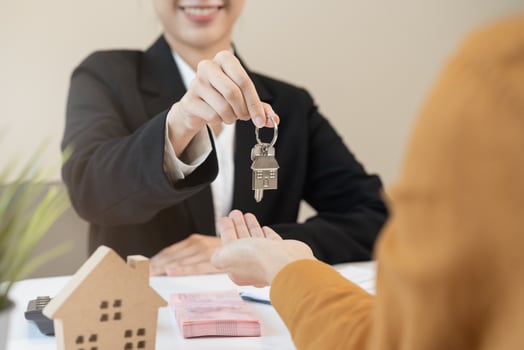 Asian agent giving a key to new owner or tenant, client after signed signature contract rental purchase, buyer apartment, home with landlord, realtor. Banker agreement mortgage loan. Property lease. photo
