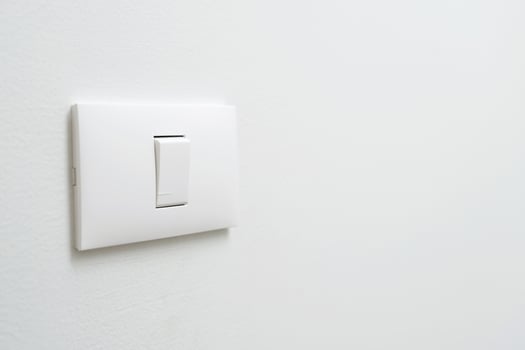 Turn off the light, close up female hand is closing the power switch. Save energy, reduce global warming. photo