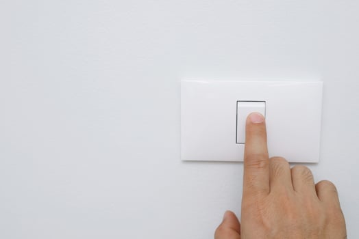 Turn off the light, close up female hand is closing the power switch. Save energy, reduce global warming. photo