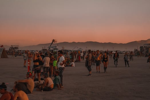 People walking towards sunset at a festival in the desert at the Burning Man Festival. photo