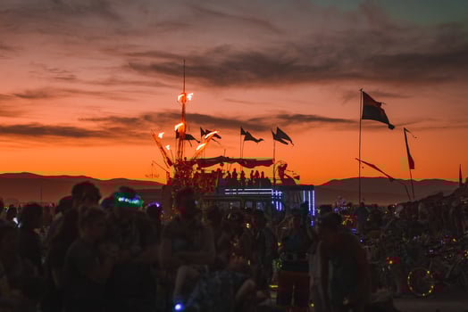 People walking towards sunset at a festival in the desert at the Burning Man Festival. photo