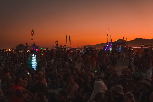 People walking towards sunset at a festival in the desert at the Burning Man Festival. photo