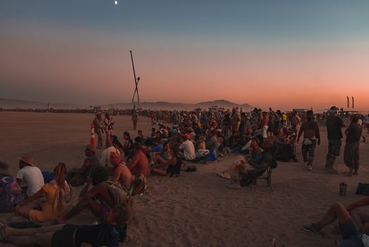 People walking towards sunset at a festival in the desert at the Burning Man Festival. photo