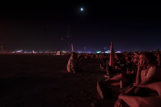 People walking towards sunset at a festival in the desert at the Burning Man Festival. photo