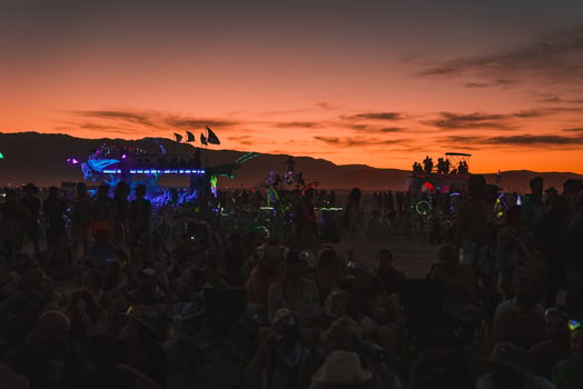 People walking towards sunset at a festival in the desert at the Burning Man Festival. photo