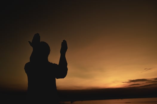 Silhouette Young asian muslim man praying on sunset,Ramadan festival concept photo