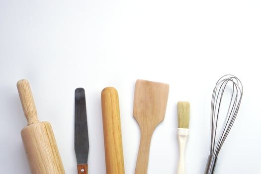 Top view kitchenware wooden rolling pin, wooden spatula and egg beater on white background. Materials or kitchen equipment for bakery. photo