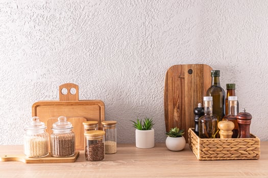 a set of various kitchen utensils and cans, bottles for food storage, wooden cutting boards on a wooden countertop in a modern kitchen. photo