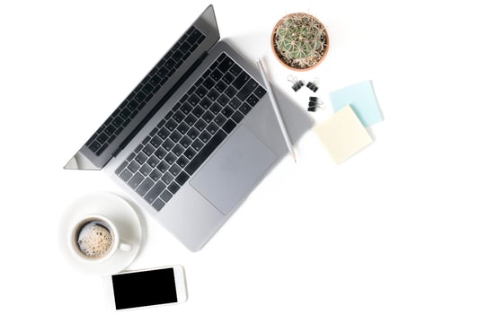 Modern workspace with coffee cup, smartphone, and laptop photo