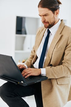 fashionable man holding a phone laptop office lifestyle photo