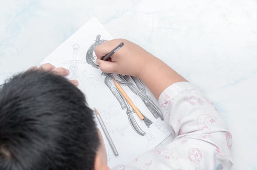 school boy drawing picture with color pencil, photo