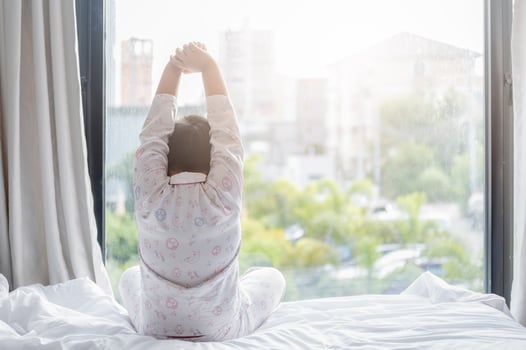 obese fat boy in pajamas is sitting on  bed photo