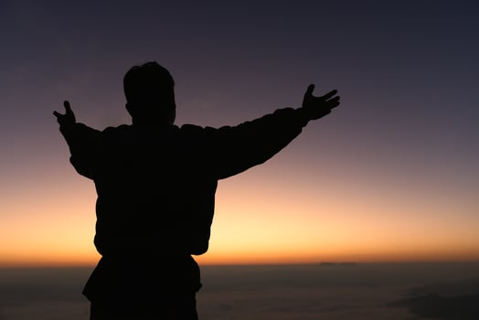 Silhouette of a man praying on the mountain at sunrise, beautiful landscape, spirituality and religion,man praying to god. Christianity concept. photo
