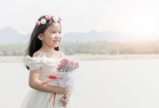 cute little bride hold rose bouquet on nature background photo