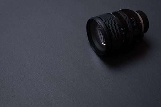 Modern camera lens on black office desk with copy space photo