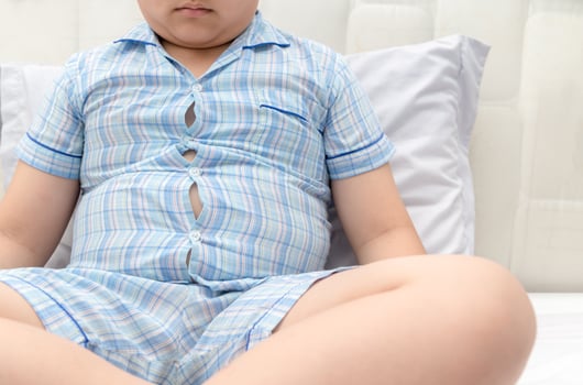 Obese fat boy overweight. Tight shirt of pajamas photo