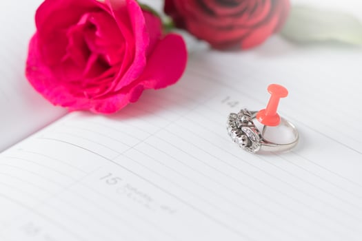 Diamond ring on calendar book with pink rose photo