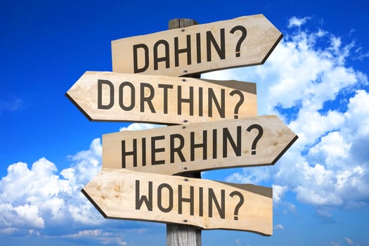 Destination Concept - Wooden Signpost with Four Arrows, Sky with Clouds in Background photo
