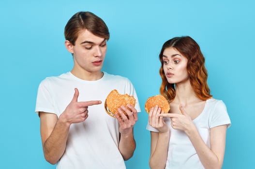 man and woman in t-shirts with hamburgers in the hands of fast food diet photo