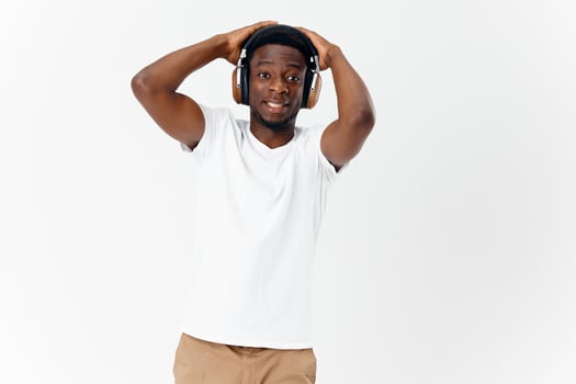 man of african appearance in white t-shirt wearing headphones music photo