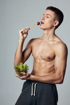 athletic guy with a pumped-up torso healthy food salad plate meal workout photo