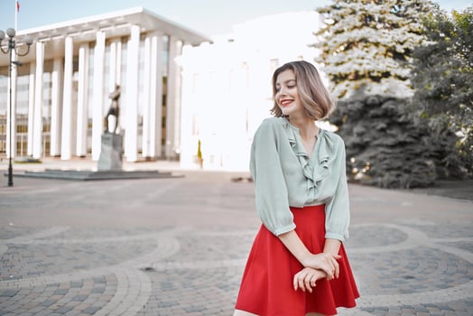 cheerful blonde in a red skirt on the street walk lifestyle photo