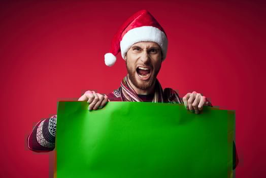 handsome man in a christmas hat with green mockup red background photo