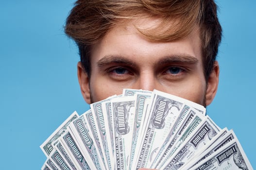 man holding money close-up wealth success blue background photo