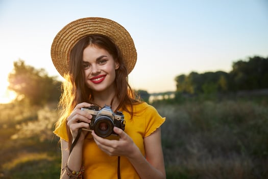 Woman photographer camera in hands smile red lips hat attractive look nature photo
