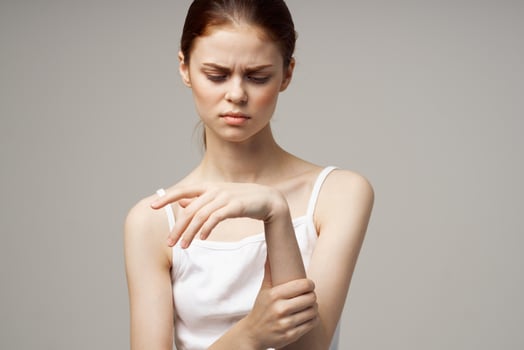 woman in white t-shirt arm pain arthritis chronic disease light background photo