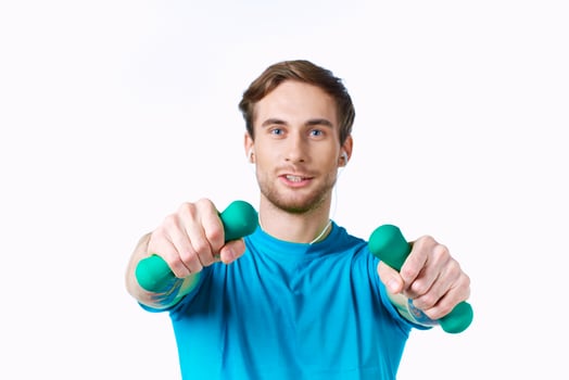 sports man with dumbbells in hands in headphones fitness exercise light background photo