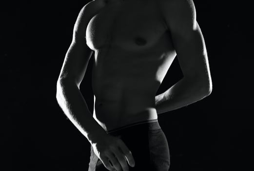 a man in black panties with a pumped-up body black and white photo