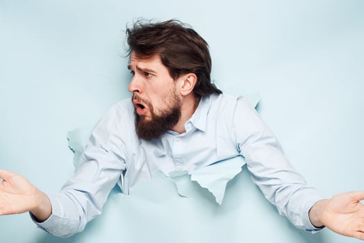A man in a shirt peeks out from behind the wall of a career work emotions photo