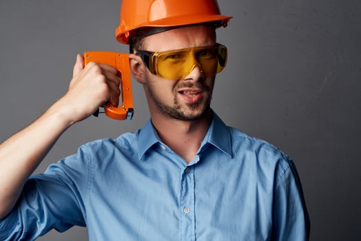 Cheerful man in orange hard hat construction professional tools photo