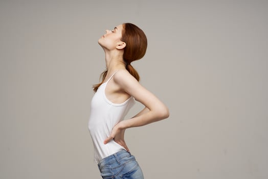 woman in white t-shirt back pain health problems osteoporosis studio treatment photo