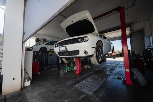 Muscle car with open hood at service repair station in lift. photo