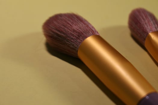 A thick purple makeup brush is used for makeup. photo